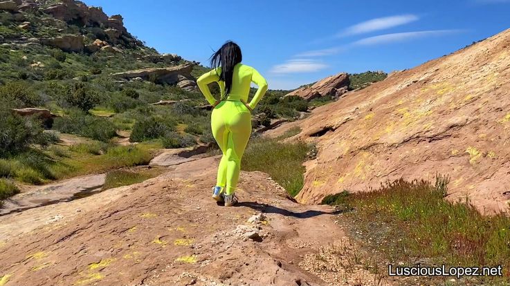 Luscious Lopez outdoors in neon jumpsuit